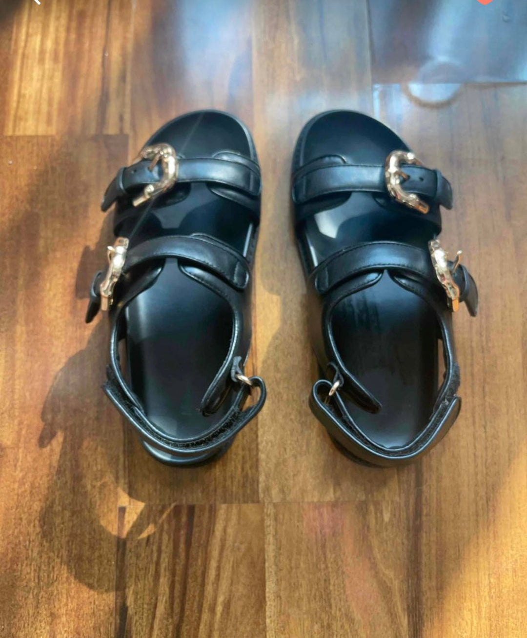 Image of Stylish black sandals with gold buckle